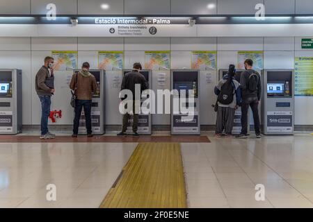 Palma de Mallorca, Espagne; mars 04 2021: Gare intermodale Plaza de España. Personnes prenant des billets à la machine à tickets de métro et portant un masque facial Banque D'Images