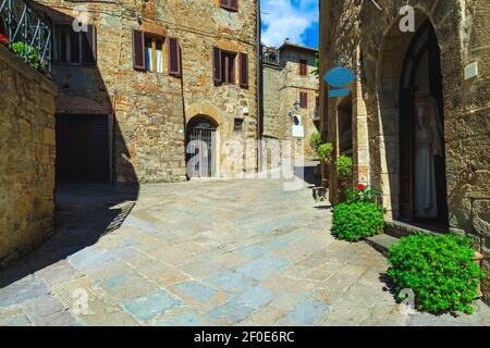 Belle vue sur la rue toscane. Maisons rustiques en pierre et rue pavée. Entrées décorées de plantes vertes ornementales, Monticchiello, Toscane, Italie, E Banque D'Images