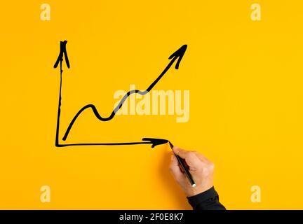 Main de homme dessin d'un graphique de secteur d'activité avec une pente croissante sur fond jaune. Augmentation du bénéfice financier ou des performances. Banque D'Images