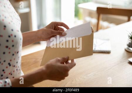 Les mains des femmes mettent la lettre dans l'enveloppe avant d'envoyer par la poste Banque D'Images