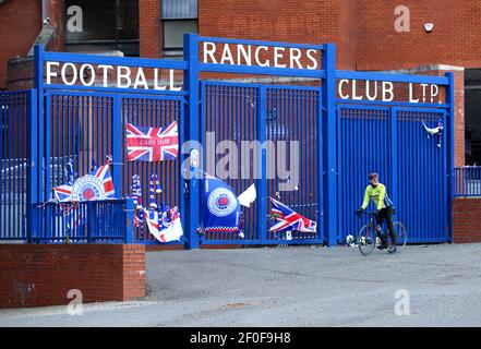 Un cycliste s'arrête devant les portes du stade Ibrox, stade du Rangers FC. Date de la photo: Dimanche 7 mars 2021. Banque D'Images