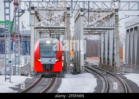 Le train à grande vitesse traverse le pont le jour de l'hiver. Banque D'Images