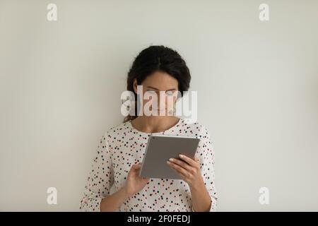 Jeune femme concentrée utilisateur de tablette électronique numérique naviguer sur Internet Banque D'Images