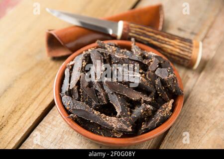 Biltong fait de chevreuil en jachère qui a été séché à l'air et séché avec du sel, du vinaigre et du sucre et diverses épices, y compris la coriandre écrasée Banque D'Images