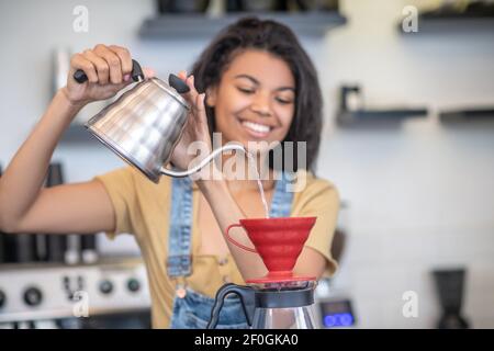 Femme concentrée préparant du café à l'aide d'un égouttoir Banque D'Images