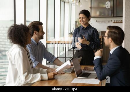 Femme d'affaires indienne souriante à la tête d'une réunion d'entreprise avec divers collègues Banque D'Images