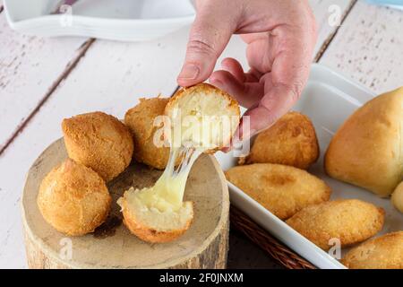 Les Brésiliens salés sont farcis avec du fromage mozzarella fondu. Servi sur une bûche en bois. Banque D'Images