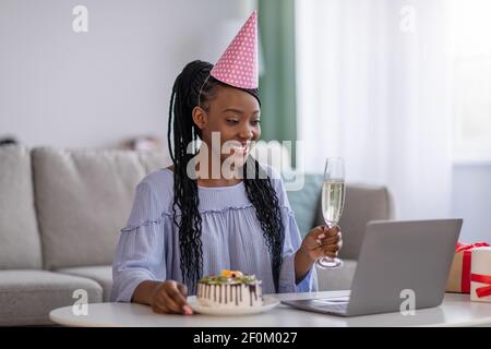 Gaie femme noire ayant fête d'anniversaire en ligne Banque D'Images