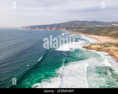 Vue aérienne de la côte portugaise sauvage près de la plage de Guincho et de Cabo da Roca point de repère, vue de l'océan Atlantique mer rugueuse s'écrasant sur les falaises rocheuses n Banque D'Images