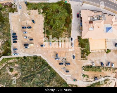 Vue aérienne des véhicules garés dans un parking d'un restaurant sur les falaises face à l'océan Atlantique dans le sud du Portugal, Cascais, Portugal. Banque D'Images