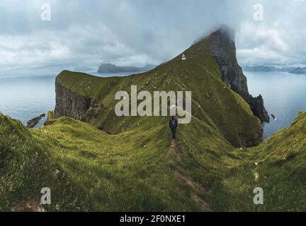 Île de Kalsoy avec phare de Kallur sur les îles Féroé, Danemark, Europe. Nuages sur de hautes falaises, océan Atlantique turquoise et vues spectaculaires. Banque D'Images