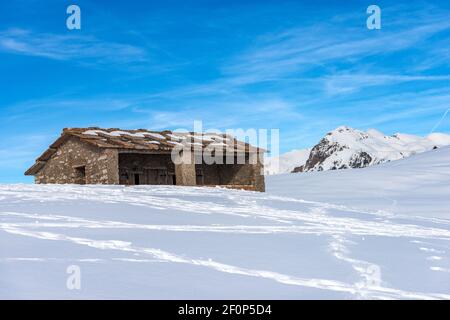 La vieille vache en pierre s'est délassée sur le plateau de Lessinia, dans le parc naturel régional, en hiver avec de la neige. En arrière-plan, le pic de Monte Carega. Italie, Europe. Banque D'Images