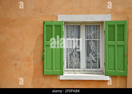 Façade typiquement provençale avec un mur en stuc ocre vénitien et des volets en bois vert clair à Martigues, Bouches-du-Rhône France. Banque D'Images