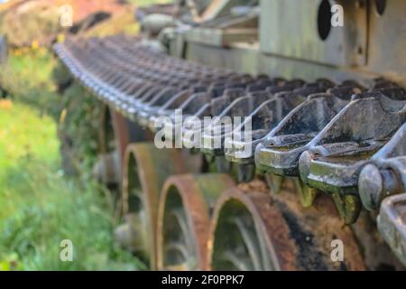 La chenille d'un ancien réservoir soviétique sur fond de roues rouillées. Mise au point sélective Banque D'Images