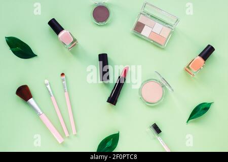 Produits cosmétiques de maquillage sur fond vert clair. Vue de dessus, plan d'appartement. Banque D'Images