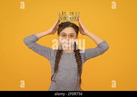 L'admiration est la récompense. Petite beauté queen fond jaune. Un petit enfant a reçu la couronne en récompense. Cadeau de bijoux. Récompense et reconnaissance. Fier champion. Succès et triomphe. Banque D'Images