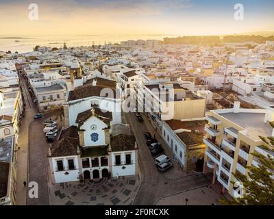 Vue aérienne d'Olhao avec une église en premier plan au coucher du soleil, Algarve, Portugal Banque D'Images