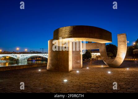 Œuvres d'art illuminées Monumento a la Tolerancia, promenade au bord de la rivière Muelle de la sal au Rio Guadalquivir, pont rétroéclairé Puente de Triana Banque D'Images