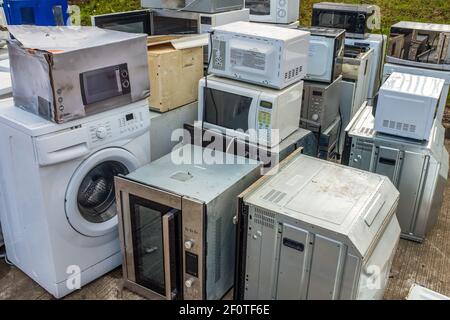 Une collection d'appareils ménagers (fours, micro-ondes et lave-linge) laissés à UN centre de vidage ou de recyclage Banque D'Images