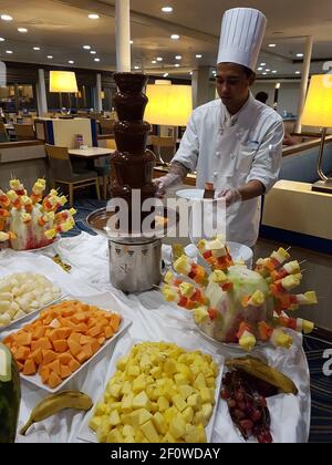 Ancona, Italie - septembre, 10 2018: Faire cuire la fondue au chocolat chaud avec différents fruits au restaurant à bord du bateau de croisière Banque D'Images