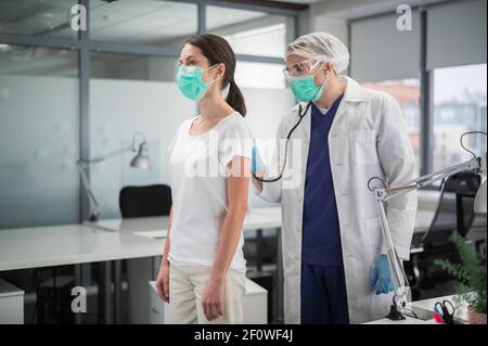 Pendant le rendez-vous, le médecin écoute les poumons du patient pour une respiration sifflante Banque D'Images