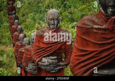 Des centaines de vieilles statues de moines bouddhistes collectant des almes entourent le Bouddha Win Sein Taw ya à Mawlamyine, au Myanmar (Birmanie). Banque D'Images