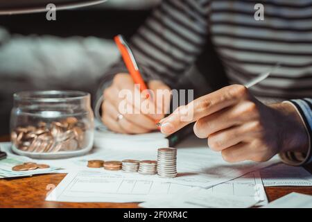 Gros plan récolte frustré homme calculant les dépenses mensuelles, la gestion du budget familial, la saisie de données au bureau à domicile dans la pile de papier avant, le dosume de prêt Banque D'Images