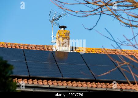 une vue rapprochée d'une cheminée sur un résidentiel toit avec panneaux solaires Banque D'Images