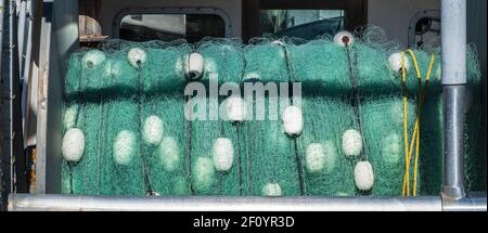 rouleau géant de filets de pêche vert aqua avec flotteurs blancs sur un bateau Banque D'Images