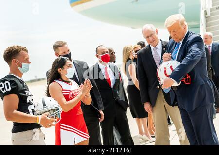 Le président Donald Trump signe un casque de football pour le meneur de l'école secondaire d'Odessa, Brissa Hinojosa, rejointe par le joueur de football de l'école secondaire Permian, Harper Terry, après avoir débarqué Air Force One à Midland International Air and Space Port, à Midland Texas, le mercredi 29 2020 juillet, où il a été accueilli par Texas Gov. Greg Abbott ancien secrétaire à l'énergie Rick Perry Texas Lt.Gov. DaN Patrick Texas Président républicain Allen West représentant des États-Unis candidats et membres de la communauté. Banque D'Images