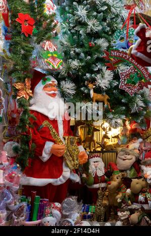 Détail des marchandises à vendre dans un magasin, Hanoi, Vietnam. Décorations de Noël dont le Père Noël et l'arbre de Noël Banque D'Images