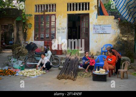 Marché de rue. Femmes vietnamiennes vendant dans la rue - légumes et canne à sucre. Thanh Liêm, Hà Nam, province de Ha Nam, Nord du Vietnam Banque D'Images