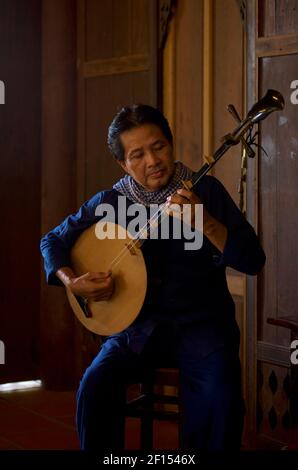 Musiciens vietnamiens jouant un luth de lune, CAN Tho, delta du Mékong, sud du Vietnam. Le đàn nguyệt, également appelé nguyệt cầm, đàn kìm est un instrument de musique traditionnel vietnamien à deux cordes. Banque D'Images