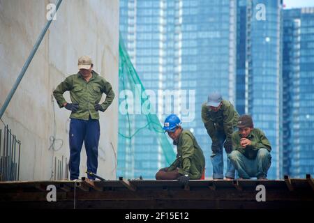 Travailleurs de la construction sur un chantier de construction en hauteur. Ho Chi Minh ville, Vietnam Banque D'Images