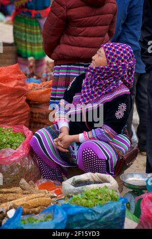 Fleur Hmong femme en tenue tribale vendant des légumes sur le marché, bac Ha, province Lao Cai. nord du Vietnam. Banque D'Images