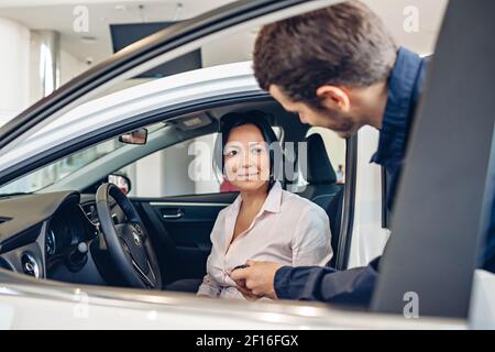 Scène de centre de service de voiture. Le mécanicien qui donne la clé de voiture au client Banque D'Images