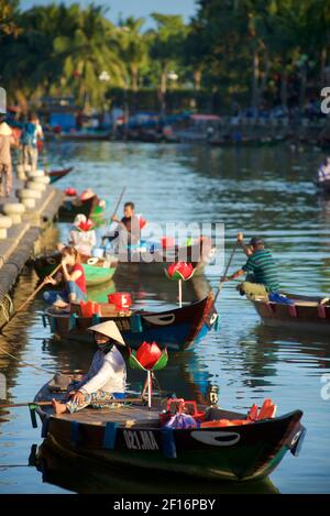 Une femme vietnamienne attend pour emmener les touristes sur un court voyage en bateau le long des canaux et de la rivière Thu bon, Hoi an, Vietnam Banque D'Images