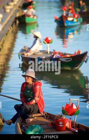 Une femme vietnamienne attend pour emmener les touristes sur un court voyage en bateau le long des canaux et de la rivière Thu bon, Hoi an, Vietnam Banque D'Images