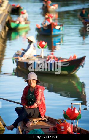 Une femme vietnamienne attend pour emmener les touristes sur un court voyage en bateau le long des canaux et de la rivière Thu bon, Hoi an, Vietnam Banque D'Images