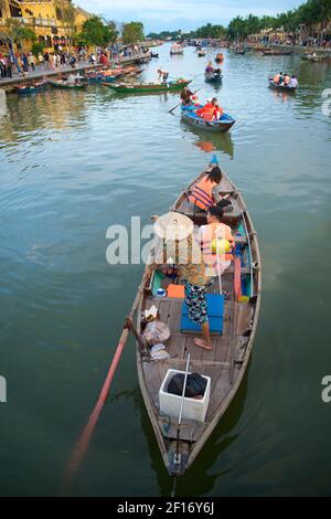 Une femme de bateau vietnamienne aviron des touristes le long d'un canal au large de la rivière Thu bon, Hoi an, Vietnam Banque D'Images