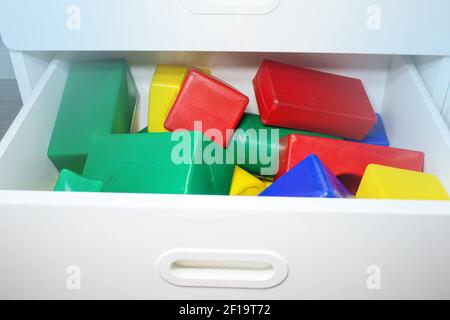 Cubes multicolores dans un tiroir d'une armoire dans une chambre d'enfant. Boîte de jeux pour enfants avec jouets pour la construction. Cubes pour enfants pour le jeu. Banque D'Images