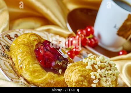 Cheesecake avec confiture sur une assiette contre le fond de la tasse avec un brin de groseilles rouges série plein recettes de cuisine Banque D'Images