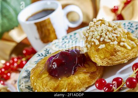 Cheesecake avec confiture sur une assiette contre le fond de la tasse avec un brin de groseilles rouges série plein recettes de cuisine Banque D'Images