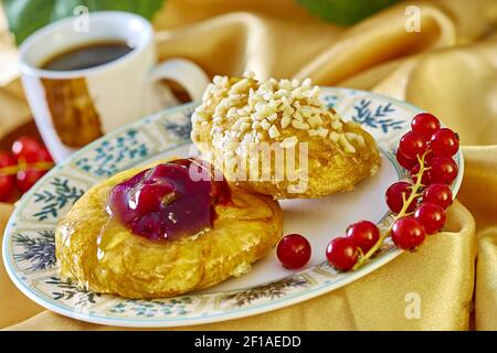 Cheesecake avec confiture sur une assiette contre le fond de la tasse avec un brin de groseilles rouges série plein recettes de cuisine Banque D'Images