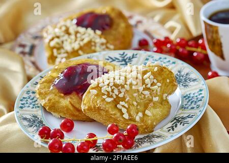 Cheesecake avec confiture sur une assiette contre le fond de la tasse avec un brin de groseilles rouges série plein recettes de cuisine Banque D'Images