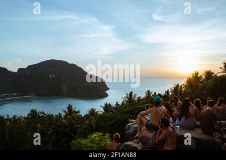 Le groupe de voyageurs étrangers assis sur le paysage de l'île Phi Phi vue de dessus pour voir la lumière du coucher du soleil à la province sud de Krabi en Thaïlande. Banque D'Images