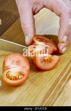 Cuire coupe une tomate sur une série de bois pleine recettes de cuisine Banque D'Images