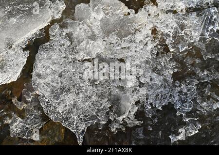 Gros plan de glace sur un ruisseau. Fond naturel d'hiver. Banque D'Images