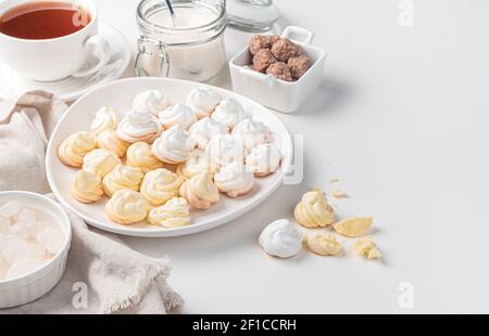 Citron et meringues blanches sur le fond d'une tasse de thé et de sucre de canne. Vue latérale avec espace de copie. Banque D'Images