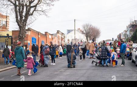 Brighton UK 8 mars 2021 - des enfants et des parents heureux arrivent à l'école primaire St Luke à Brighton ce matin, car les restrictions de verrouillage du gouvernement en Angleterre commencent à être assouplies . Les écoles et les collèges sont rouverts à tous les étudiants aujourd'hui dans toute l'Angleterre : crédit Simon Dack / Alamy Live News Banque D'Images